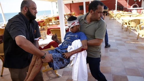 Palestinian employees of Gaza City's al-Deira hotel carry a wounded boy following an Israeli military strike nearby on the beach