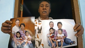 A relative shows photos of victims of the crash