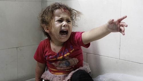 A Palestinian child shouts after Israeli forces shelled her house in Gaza City