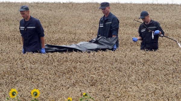Ukrainian personnel remove a body from the crash site