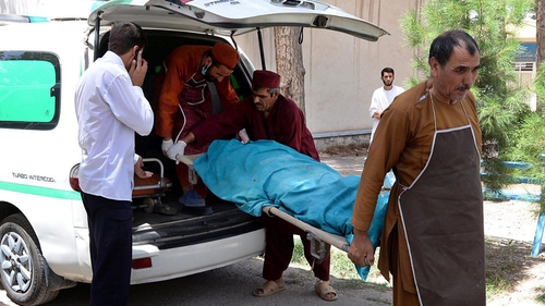 Afghan medical workers carry one of the bodies into the morgue of Herat Hospital