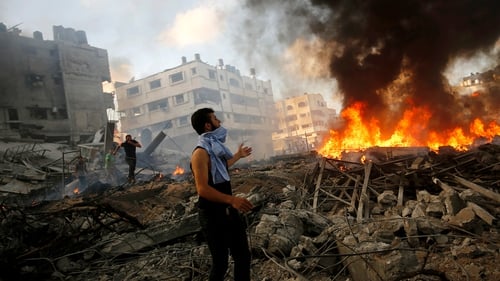 Palestinians inspect the rubble of a destroyed house after Israeli air strikes in Al Tufah neighbourhood
