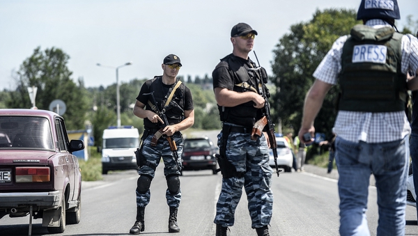Pro-Russia militants block the road behind Dutch and Australian forensic teams on their way to the MH17 crash site
