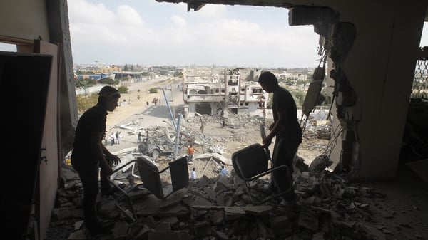 Palestinians salvage their belongings from their destroyed home in Rafah