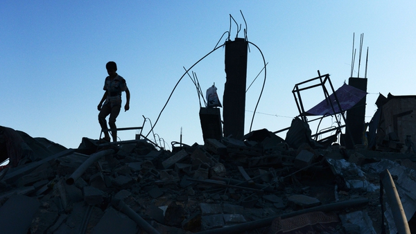 A Palestinian boy walks on the rubble of his destroyed home in Gaza City