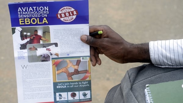 A man holds a flyer on the Ebola virus at the Murtala Muhammed International Airport in Lagos