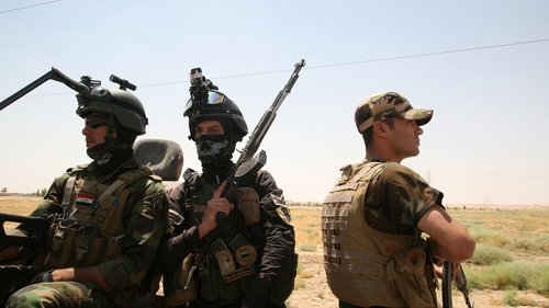 Iraqi soldiers keep watch on the main highway which links the Iraqi capital to the borders with Syria