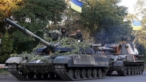 Ukrainian troops ride on a tank and a self-propelled gun near the eastern city of Luhansk