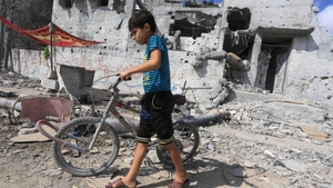 A Palestinian boy walks near the rubble of destroyed buildings as thousands of families return to their homes in Gaza