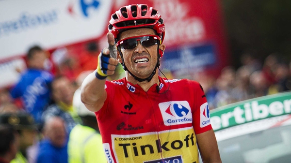Alberto Contador celebrates as he crosses the finish line to win the 16th stage