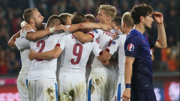 Czech Republic players celebrate at full-time in Prague as a disconsolate Daryl Janmaat trudges by