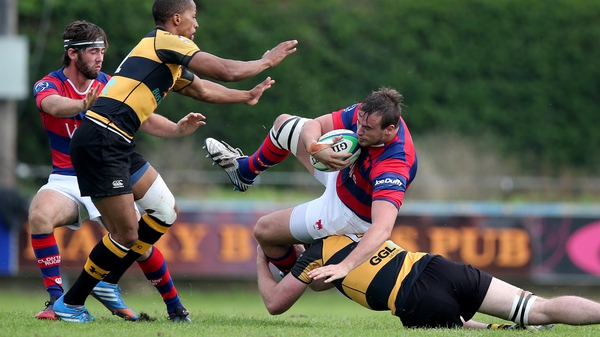 Clontarf's Ian Hirst is tackled by Darren Gallagher of Young Munster