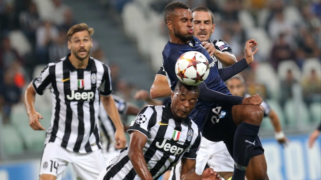 Patrice Evra gets a header away under pressure