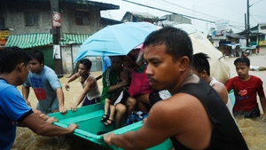 Residents are rescued by police and rescue volunteers during the floods in Manila