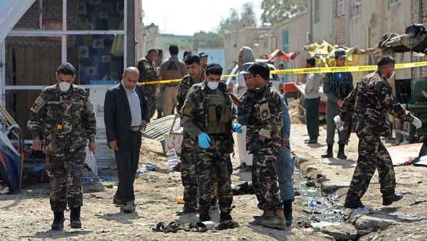 Afghan security personnel work at the site of a suicide attack near the international airport in Kabul yesterday