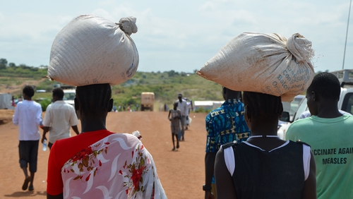 South Sudanese women carry food inside the Protection of Civilians site at a UN site in Juba
