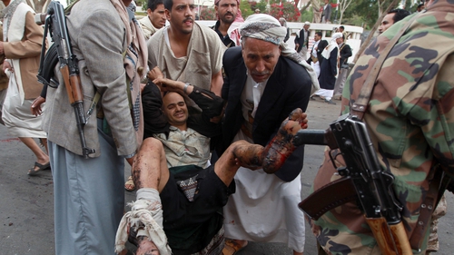 A wounded man is taken from the scene of the suicide bomb attack in Sanaa