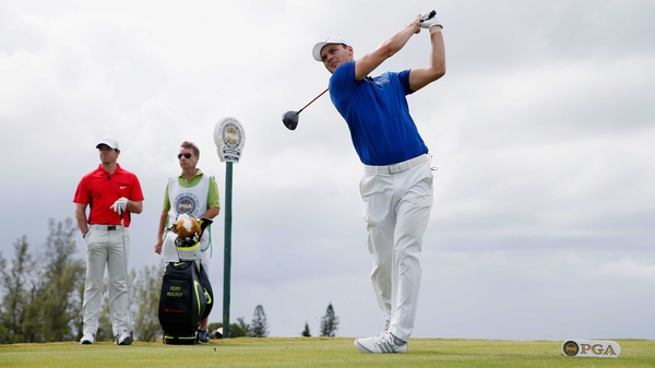 Martin Kaymer watches his tee shot on the 11th hole as Rory McIlroy of Northern Ireland looks on