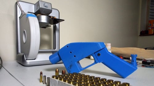 A Liberator pistol next to the 3D printer on which its components were made in the US