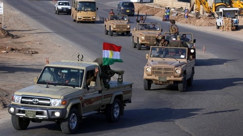 Kurdish peshmerga fighters drive through northern Iraq on their way to the Syrian town of Kobane