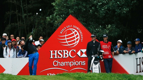 Graeme McDowell tees off on the 17th at Sheshan International as Bubba Watson looks on