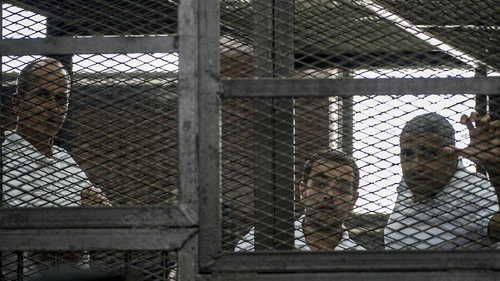 Peter Greste (L) and his colleagues, Egyptian-Canadian Mohamed Fadel Fahmy (R) and Egyptian Baher Mohamed pictured at their trial in June