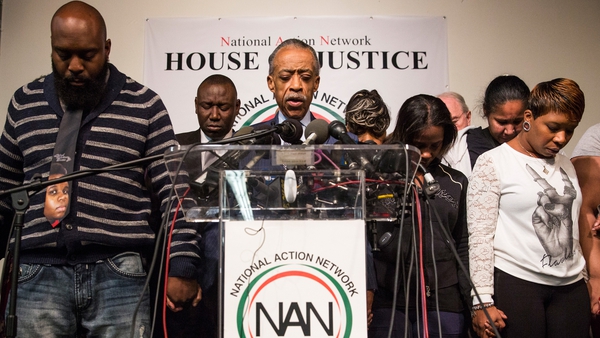 The parents of Michael Brown, left and right, bow their heads as they remember their son at a news conference in New York