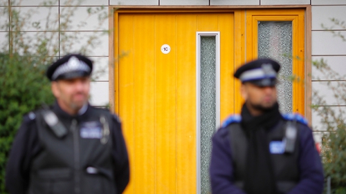 Police stand guard at a south London block of flats during an investigation into an alleged slavery case