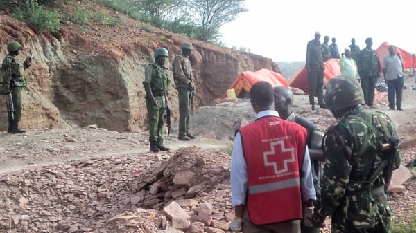 Army and medical officials examine the scene near the village of Korome