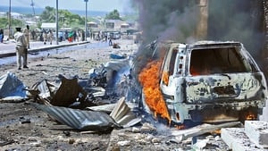 A car burns following the blast near the gates of the airport in Mogadishu