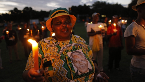 Hundreds of people carry candles during a memorial for Nelson Mandela in Johannesburg