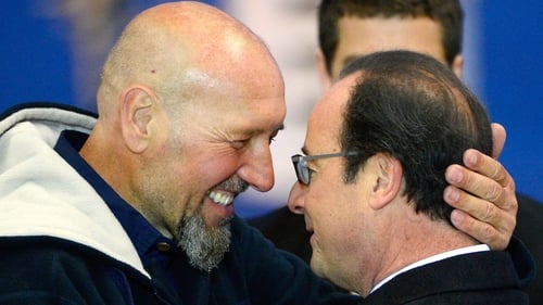 Serge Lazarevic is greeted by Francois Hollande at Villacoublay airport