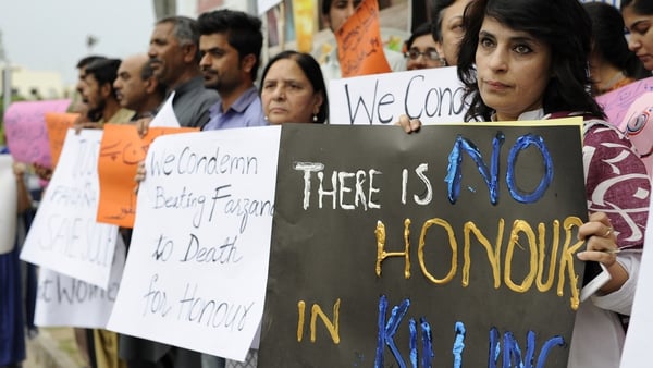 Activists carry placards during a protest in Islamabad against honour killings