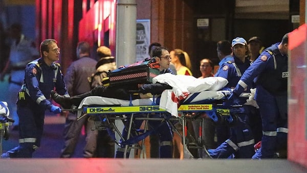 A person is taken out on a stretcher from the Lindt Cafe, Sydney