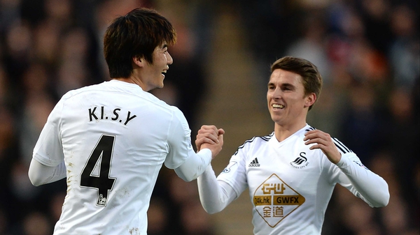 Ki Sung-Yueng of Swansea City celebrates scoring the opening goal with team-mate Tom Carroll