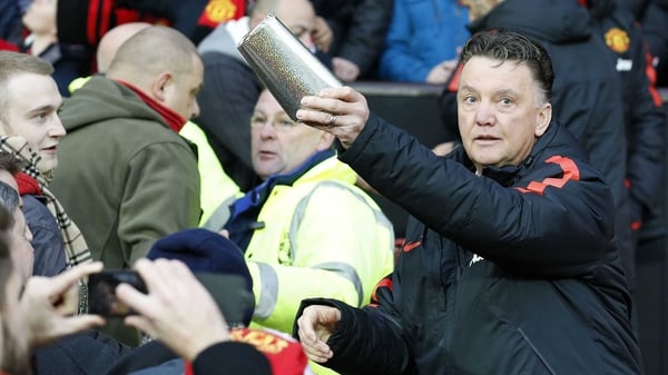 Louis van Gaal hands out presents to Manchester United fans before the team's clash with Newcastle