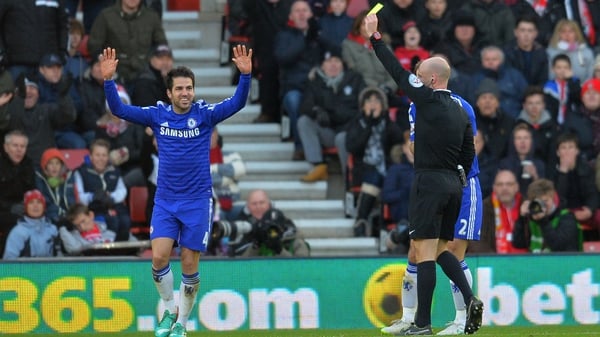 Chelsea's Cesc Fabregas earns a yellow card from referee Anthony Taylor rather than a penalty