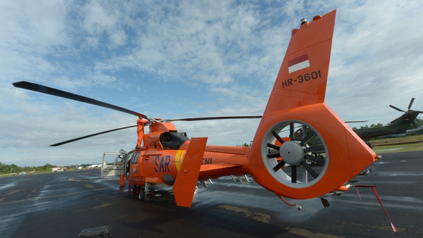 An Indonesian crew maintains a helicopter being used in the search for AirAsia flight QZ8501