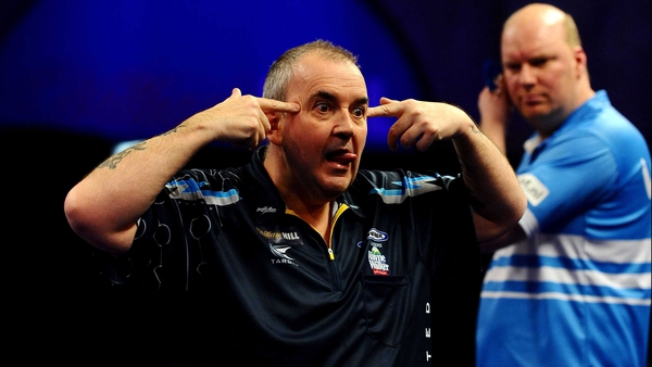 An animated Phil Taylor reacts after eventually sealing a dramatic sixth set at Ally Pally as a perplexed Vincent van der Voort looks on