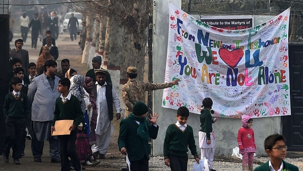 Pakistani parents leave the army public school with their children after it was reopened
