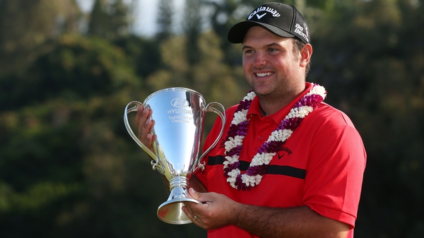 Patrick Reed poses with the winner's trophy