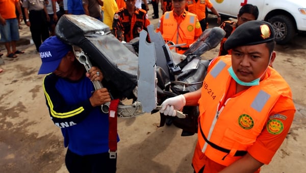 Indonesian rescue personnel carry a wrecked seat from the AirAsia Flight