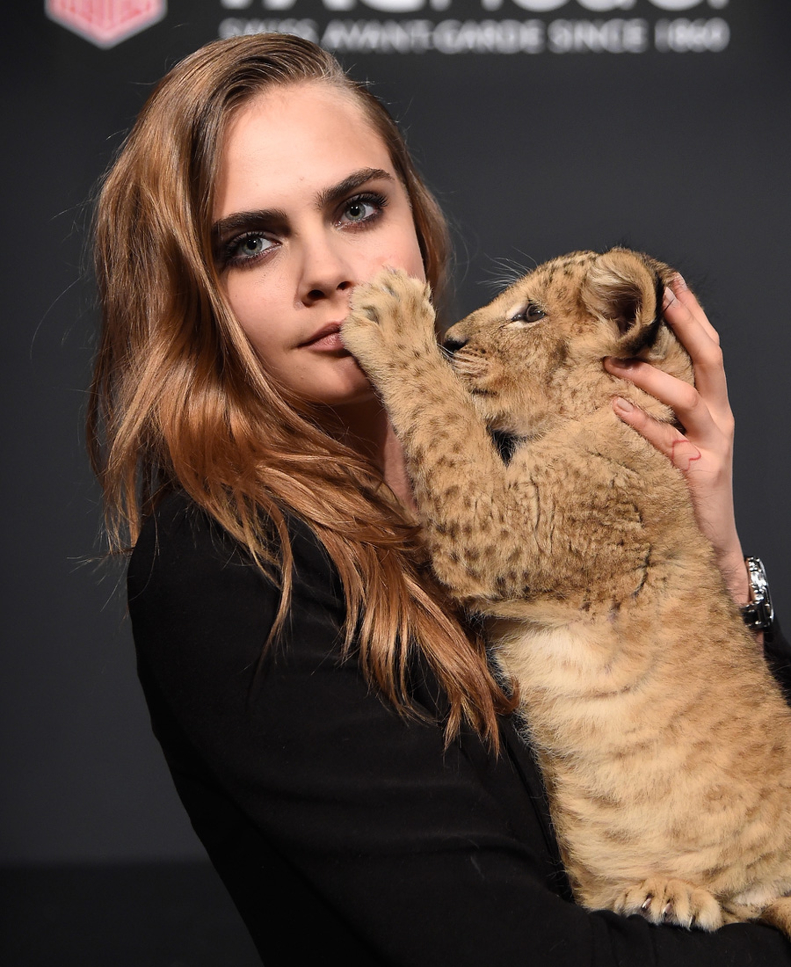 Cara Delevingne models with lion cub