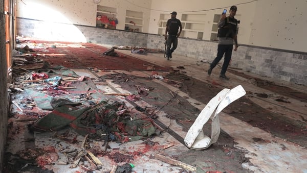 Pakistani security officials inspect the scene of the suicide bomb blast