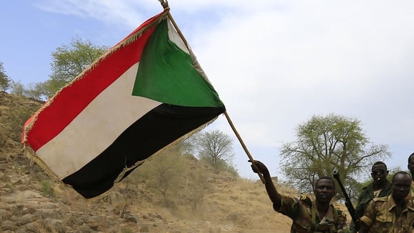 Sudanese soldiers wave the national flag