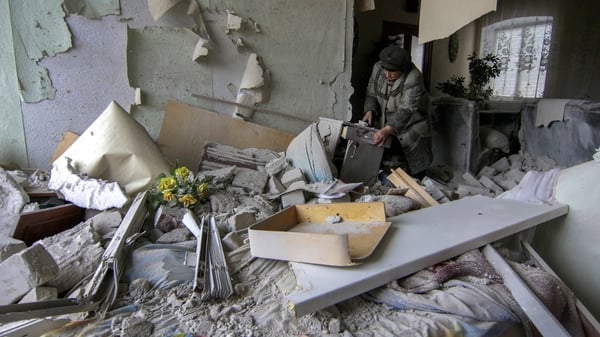 A woman inspects her home which was damaged by shelling in Sartana village not far from Mariupol