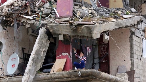 A girl sits among the rubble of destroyed buildings in Al Shejaiya neighbourhood in the east of Gaza