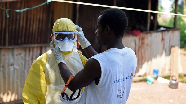 A health worker prepares to remove a corpse from a house in Freetown, Sierra Leone