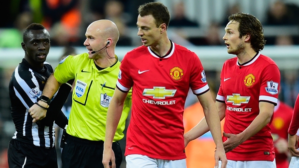 Referee Anthony Taylor steps in as Manchester United player Jonny Evans and Papiss Cisse of Newcastle