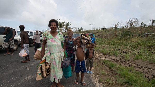 A family carries their belongings on the outskirts of Port Vila